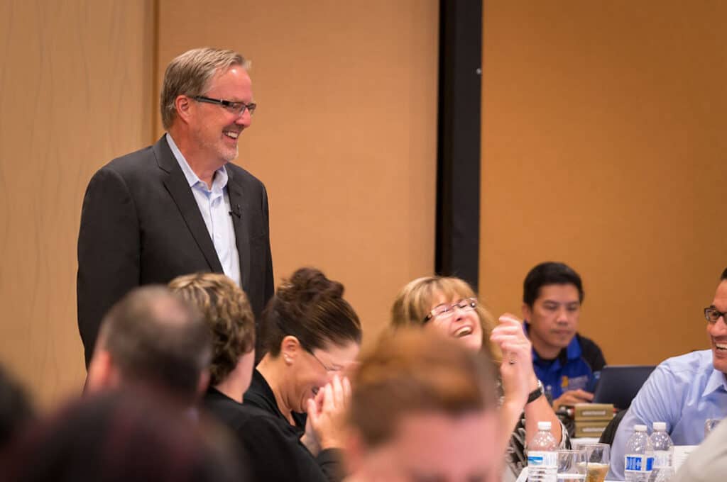 Gregg Ward facilitator mid-demonstration with participants laughing